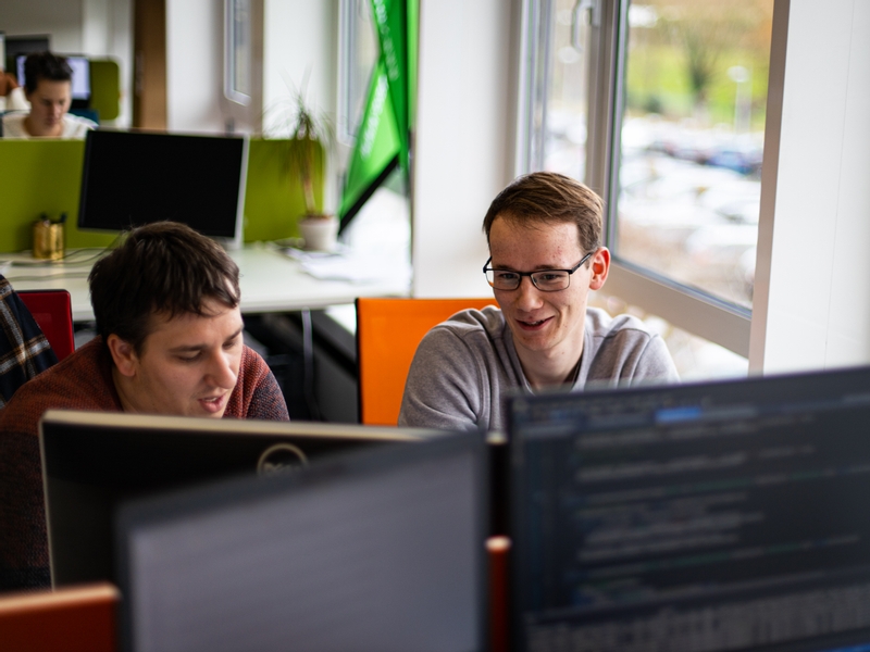 Three blastic colleagues discussing at their desk